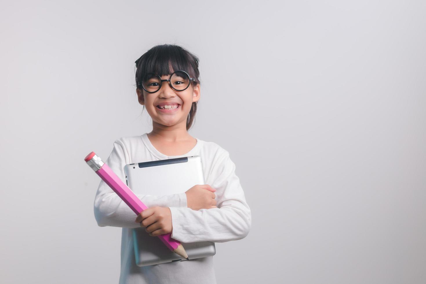 Excited young girl kid holding up big pencils in her hands.Back to school. photo