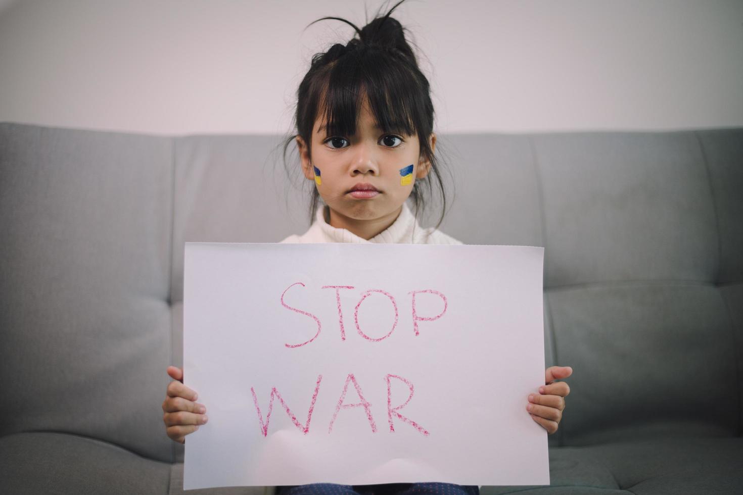 Board No war, Stop war. Little Asian girl. No war with Ukraine. Ukrainian geopolitics globe crisis. photo