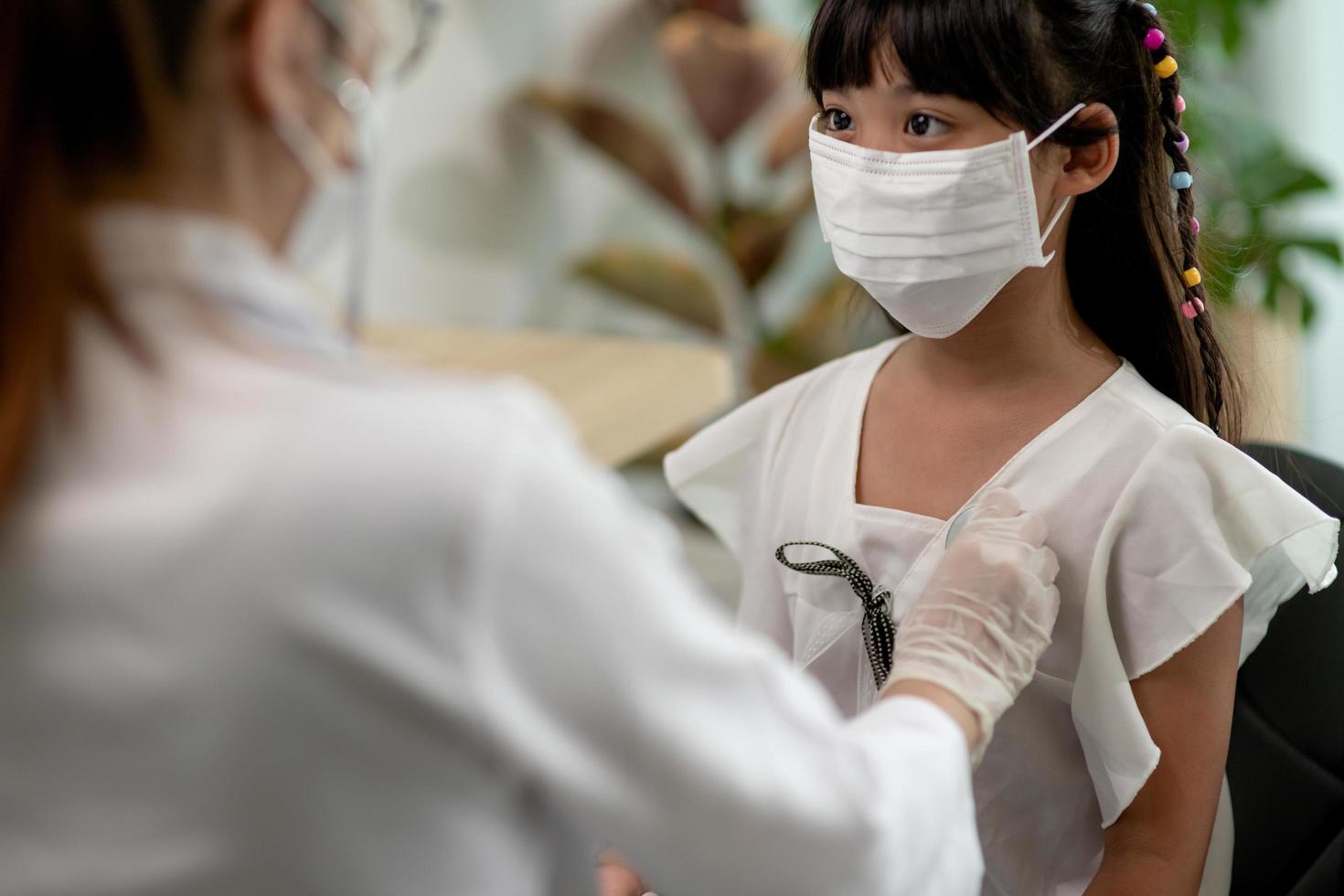 Doctor examining a little girl by stethoscope photo