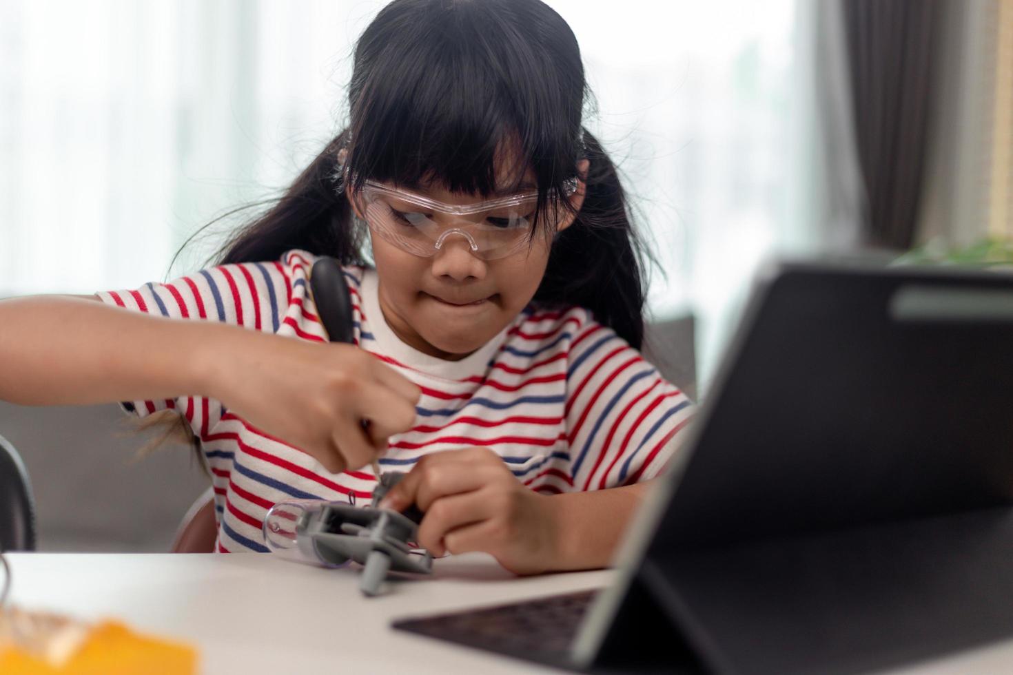 estudiante femenina construyendo y programando un vehículo robot en la clase de codificación de computadoras después de la escuela foto