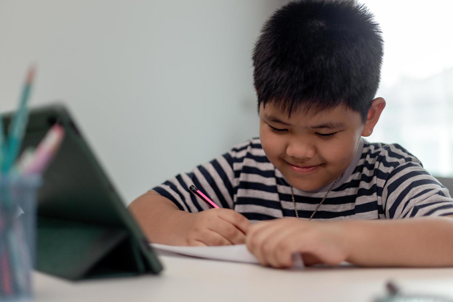Kid self isolation using tablet for his homework,Child doing using digital tablet searching information on internet during covid 19 lock down,Home schooling,Social Distance,E-learning online education photo