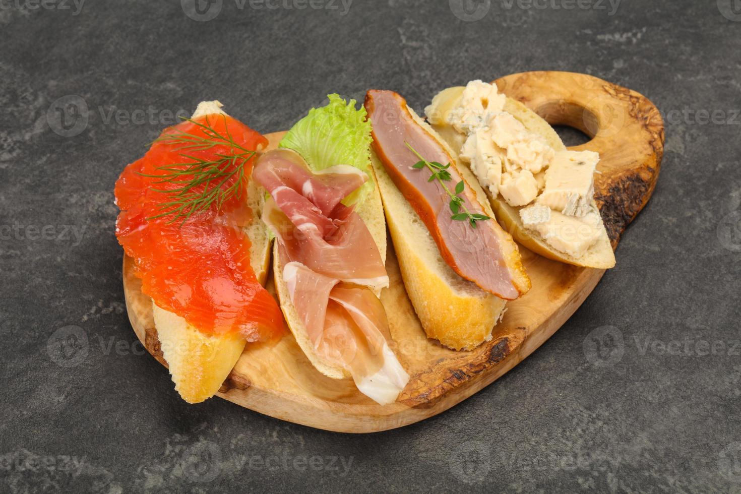 Tapas - bruschetta with prosciutto, salmon, duck and gorgonzola photo