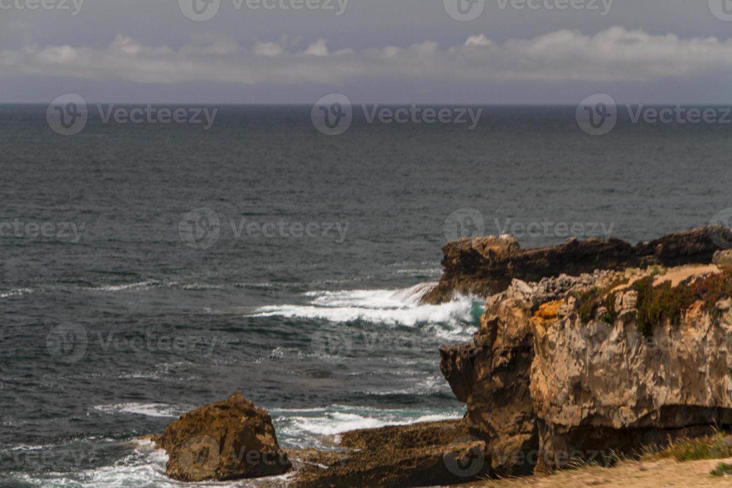 las olas peleando sobre la costa rocosa desierta del océano atlántico, portugal foto