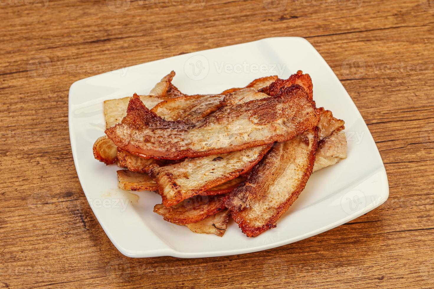 Roasted juicy bacon in the plate photo