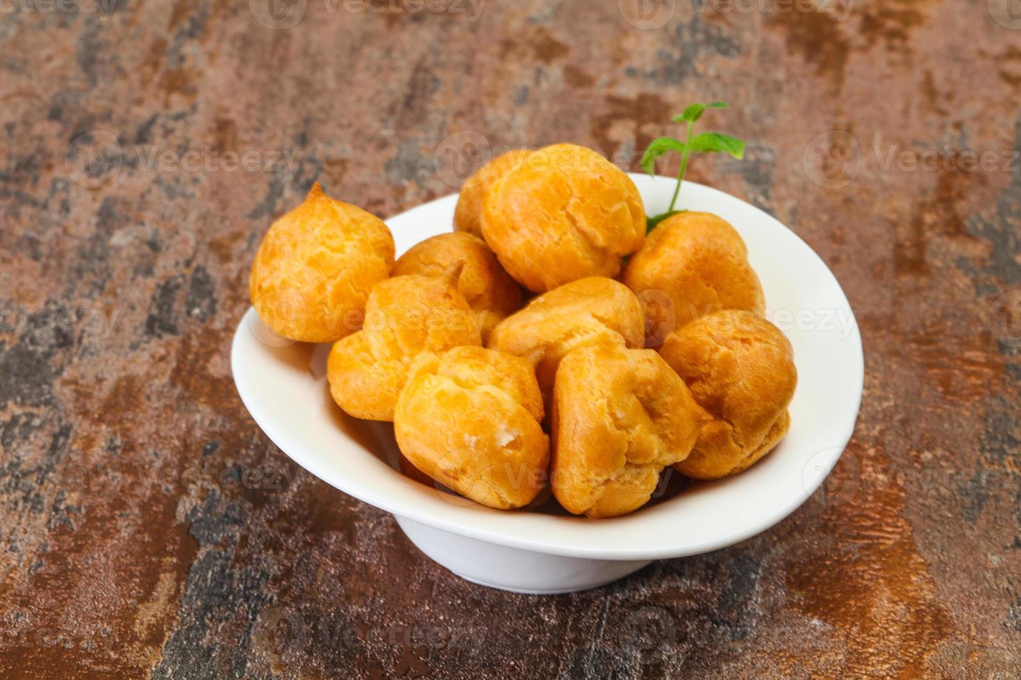Sweet tasty profiteroles heap in the bowl photo
