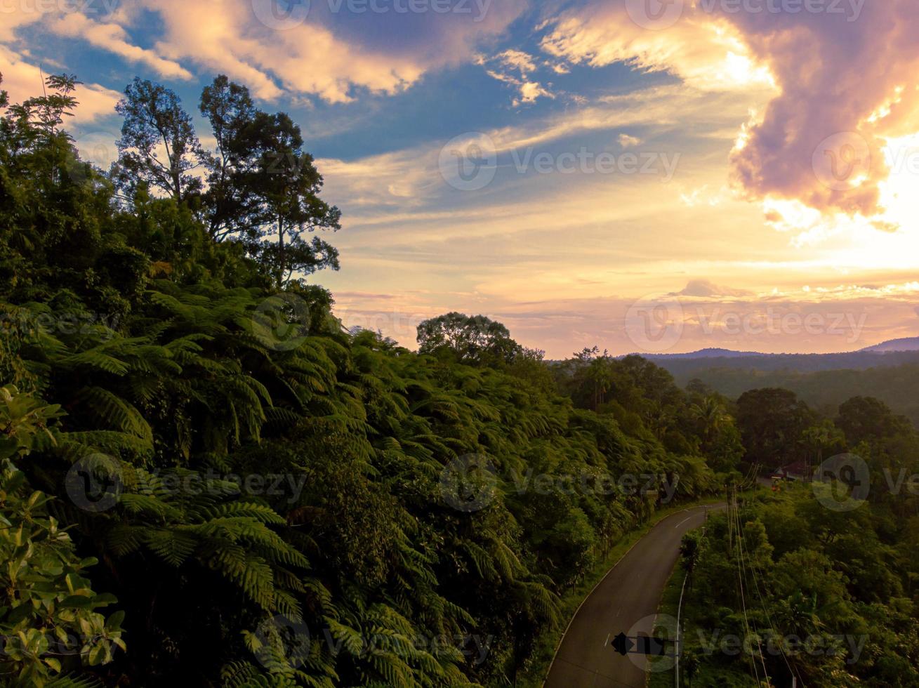 Beautiful aerial drone shot of hill on sunset with road photo