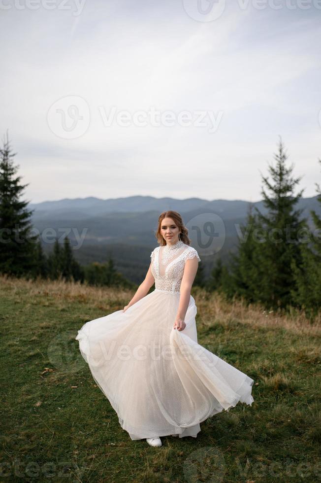 happy stylish bride and groom running and having fun in mountains on summer sunny day photo