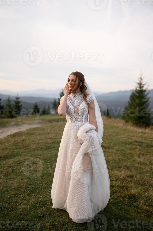 happy stylish bride and groom running and having fun in mountains on summer sunny day photo