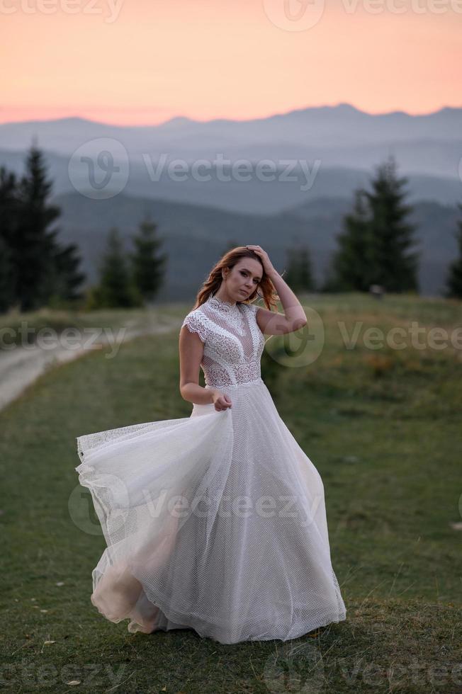 happy stylish bride and groom running and having fun in mountains on summer sunny day photo
