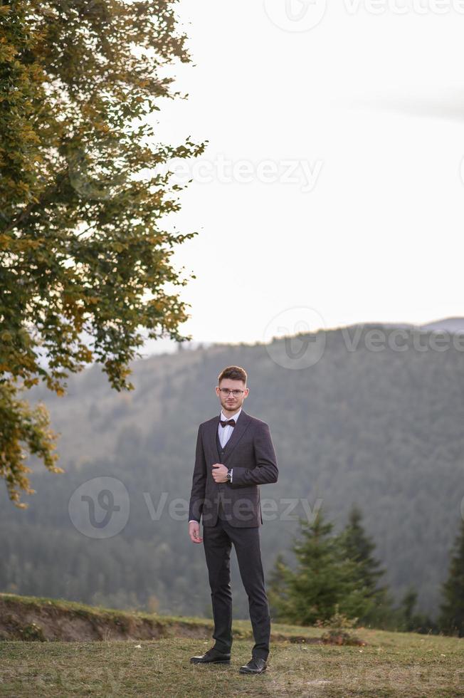 happy stylish bride and groom running and having fun in mountains on summer sunny day photo