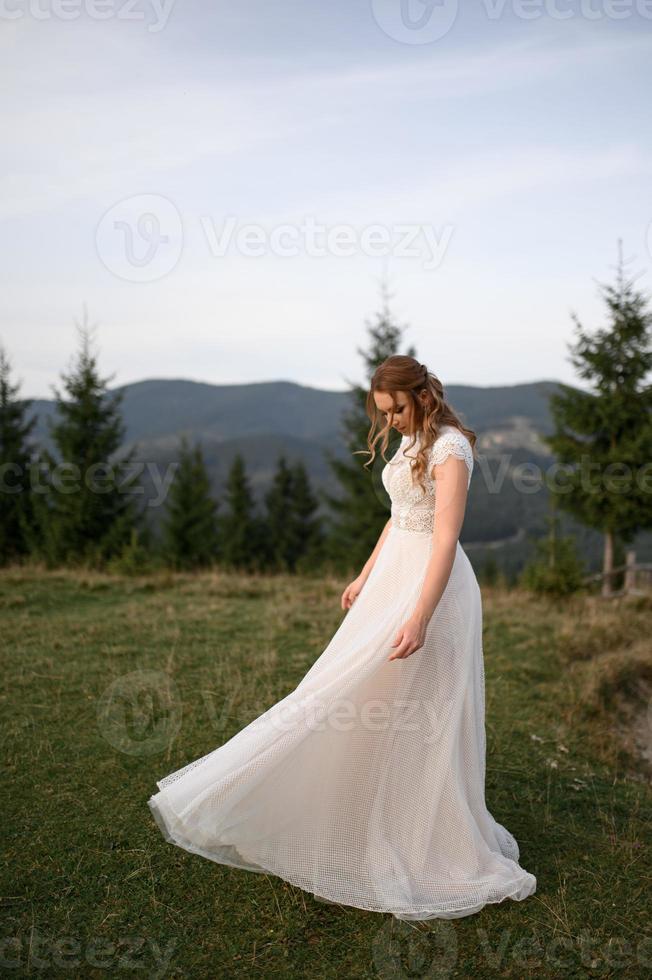 happy stylish bride and groom running and having fun in mountains on summer sunny day photo