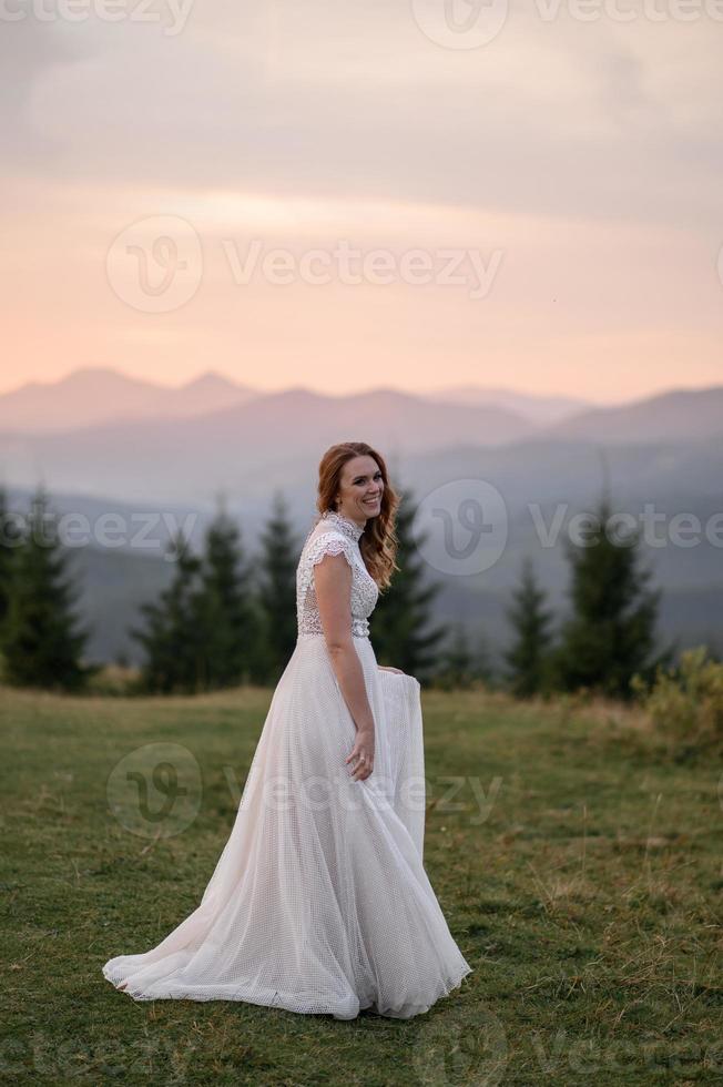 happy stylish bride and groom running and having fun in mountains on summer sunny day photo