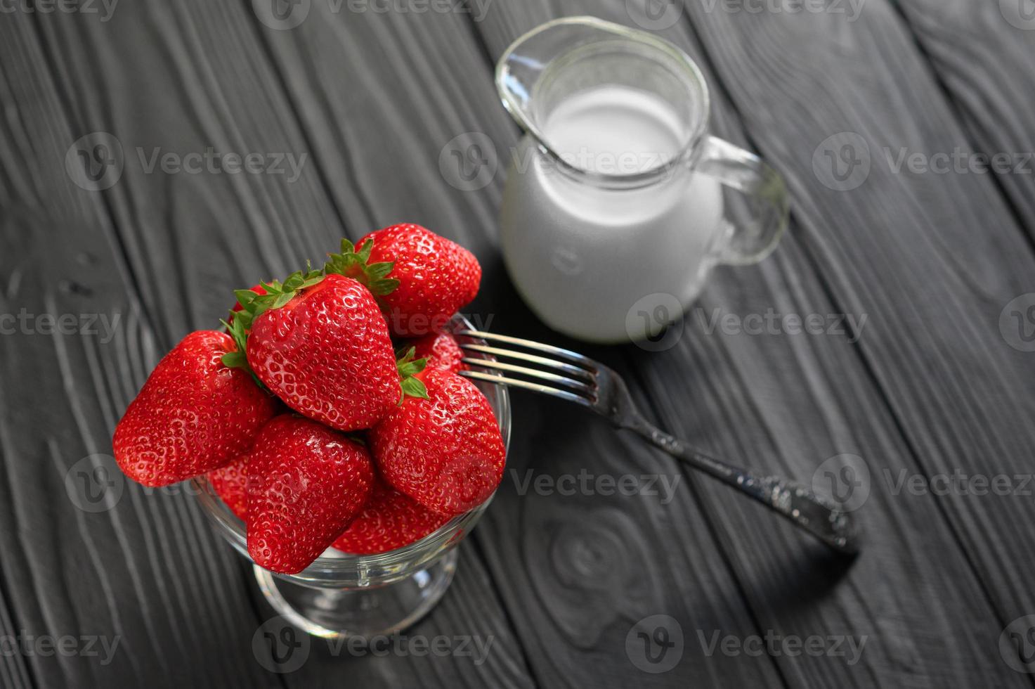 A bowl of red juicy strawberries on rustic wooden table. Healthy and diet snack food concept. photo