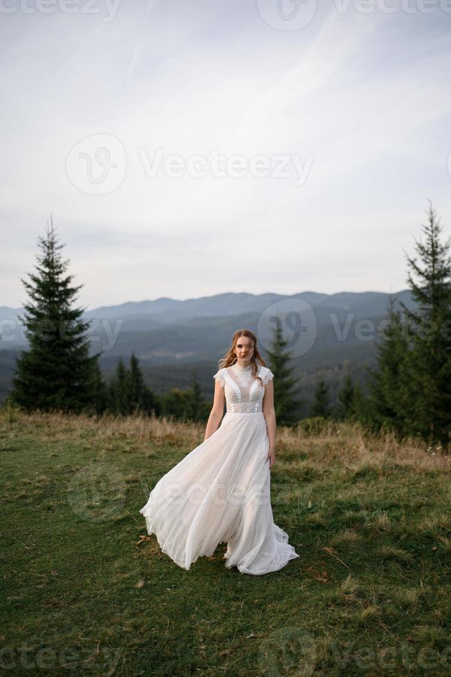 happy stylish bride and groom running and having fun in mountains on summer sunny day photo