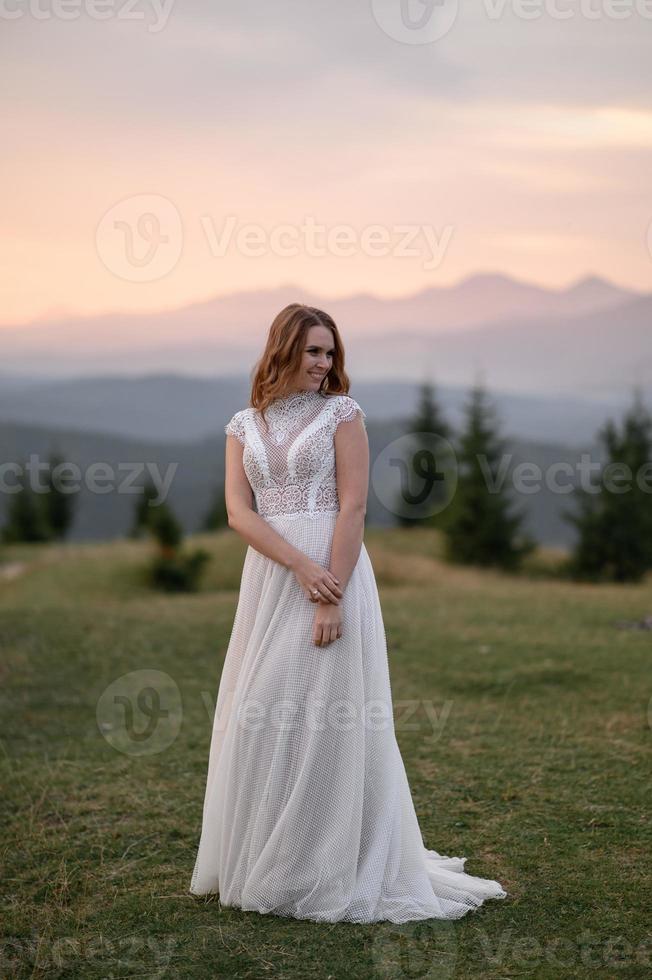 happy stylish bride and groom running and having fun in mountains on summer sunny day photo