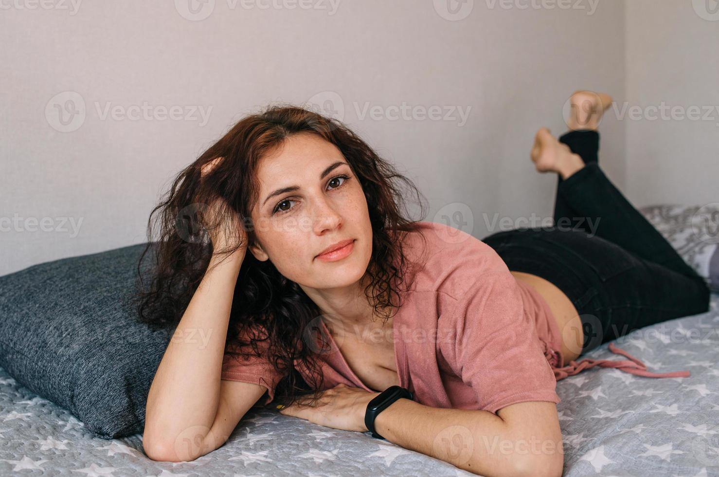 Portrait of an attractive brunette woman at home posing and looking at camera photo