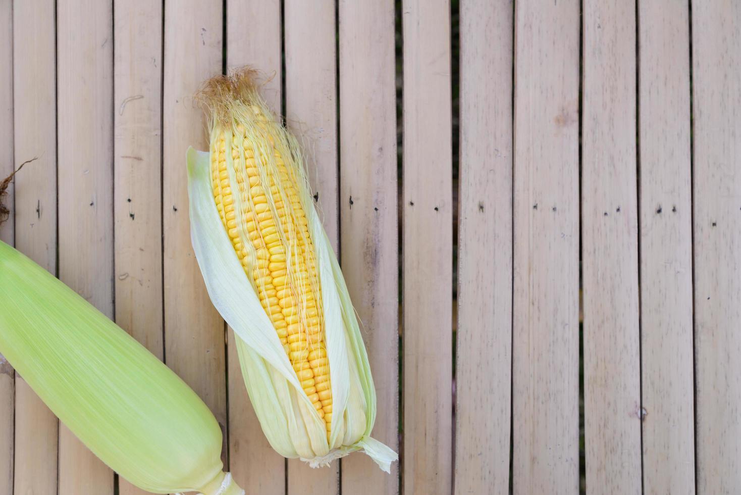 Top view of fresh corn on cobs on rustic wooden with Copyspace photo