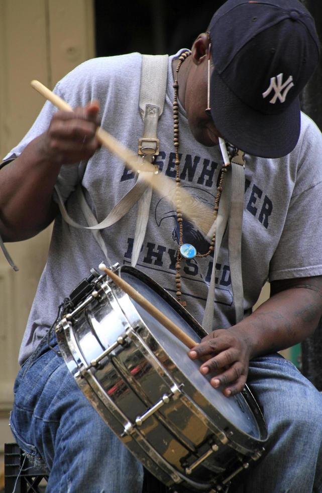 21 April 2016 - New Orleans, Louisiana - A Jazz musician performing a drum solo in the French Quarter of New Orleans, Louisiana. photo