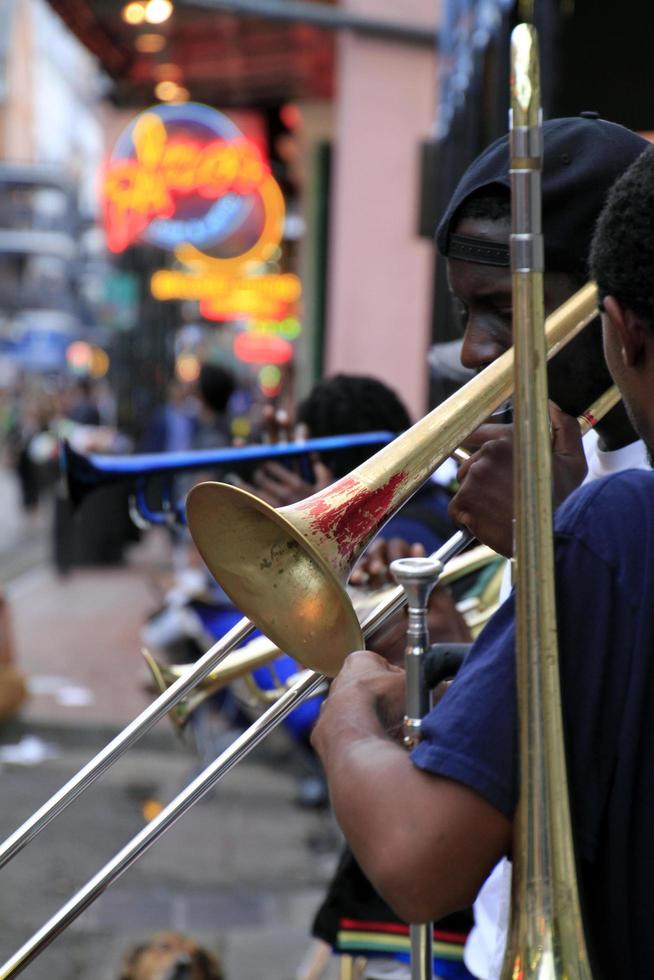 12 April 2017 - New Orleans, Louisiana - Jazz musicians performing in the French Quarter of New Orleans, Louisiana, with crowds and neon lights in the background. photo