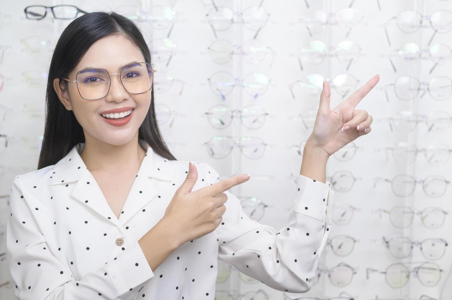 Young female customer choosing glasses in optical center, Eyecare concept. photo