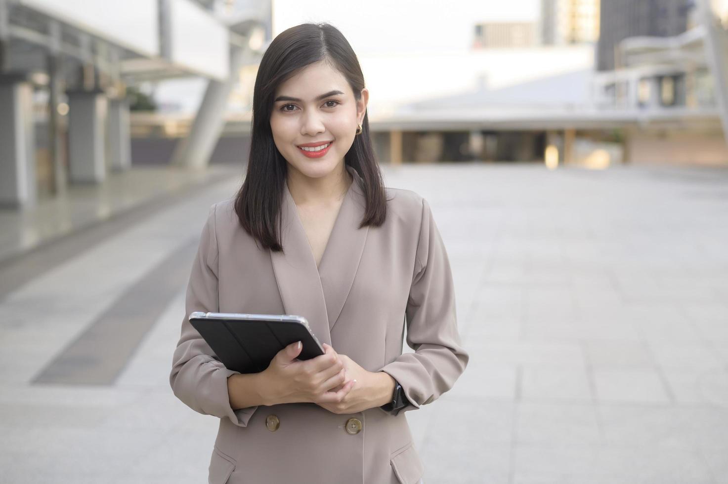 A young beautiful businesswoman is using tablet in Modern city , business technology , city lifestyle concept photo