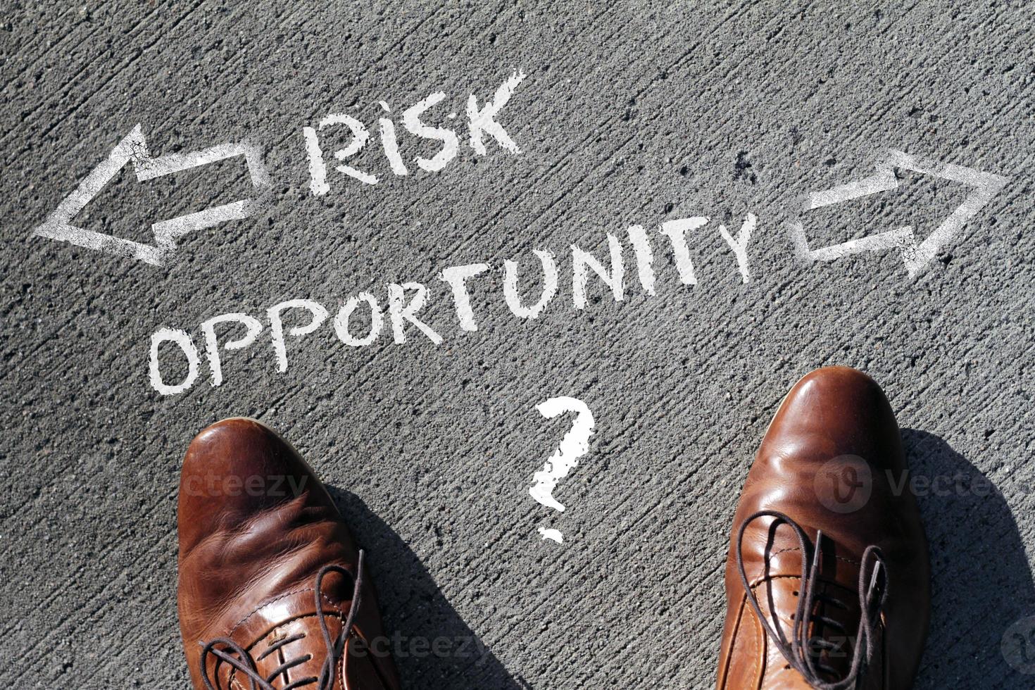 Top view on a man standing in front of the words Risk and Opportunity with arrows pointing to the left and right side of the picture photo