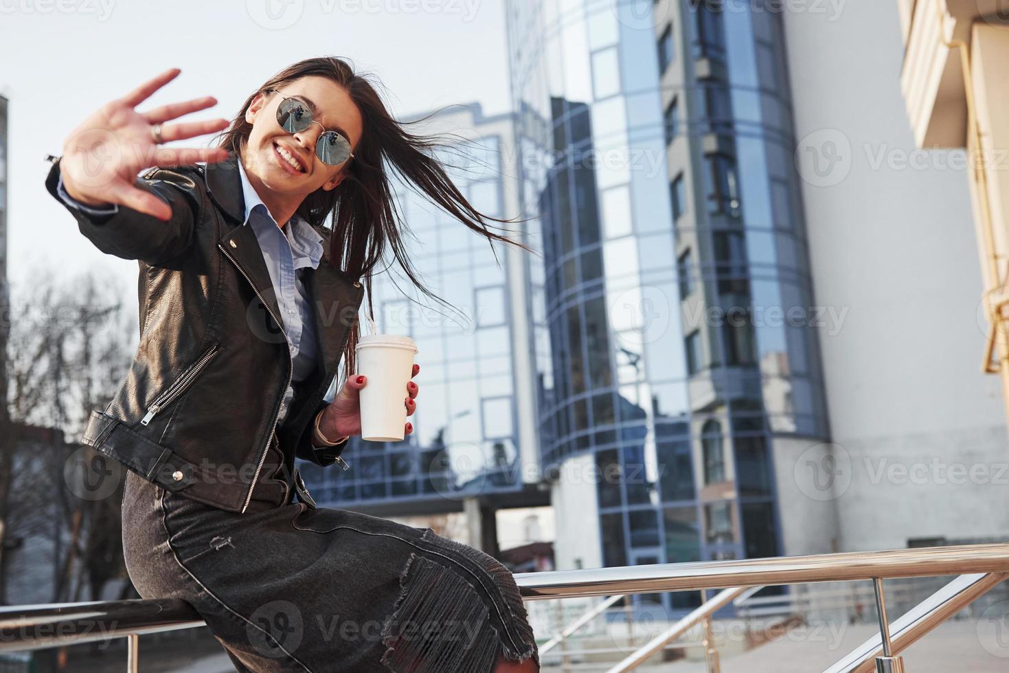 You can see photographer in reflection of glasses. Young beautiful girl in warm clothes have walk in the city at her weekends time photo