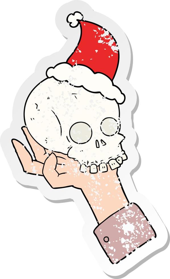 distressed sticker cartoon of a hand holding skull wearing santa hat vector