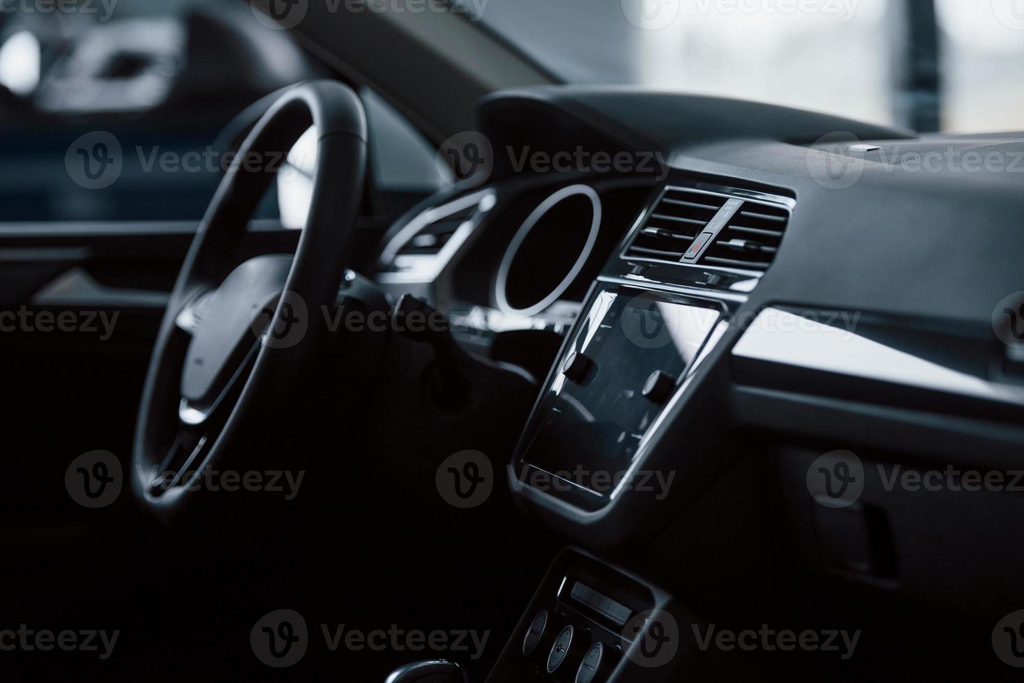 Elegant but simple design. Front part of brand new automobile. Modern black interior. Conception of vehicles photo