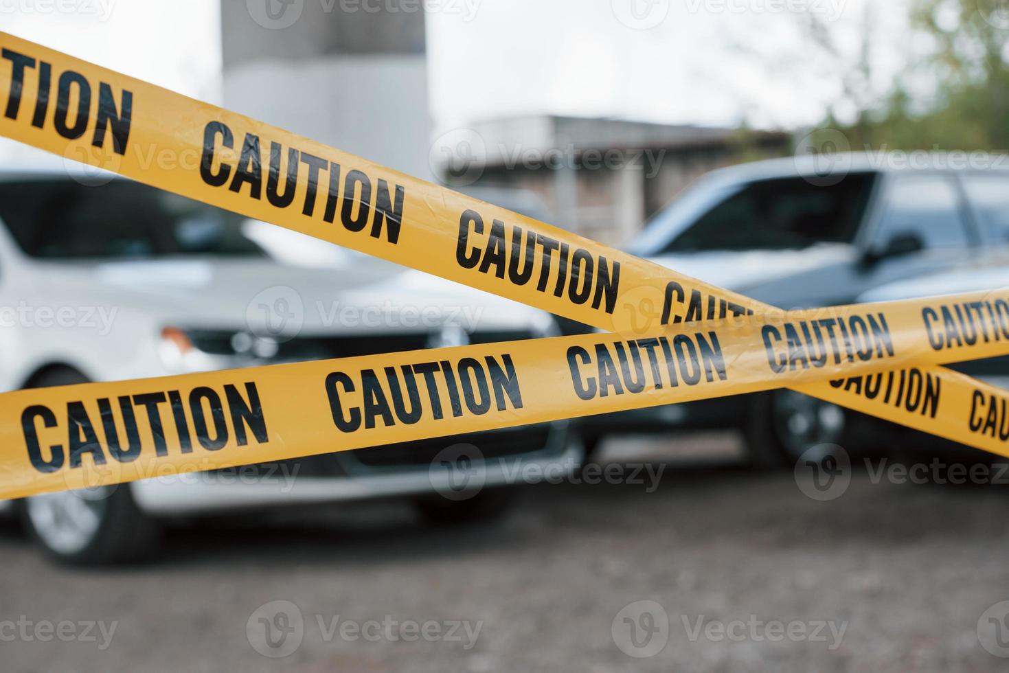 vehículos en blanco y negro. cinta amarilla de precaución cerca del estacionamiento del automóvil durante el día. escena del crimen foto