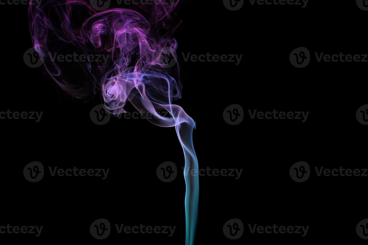 Multicolored smoke for aromatherapy relaxation on black background, beautiful swirled puffs of smoke photo