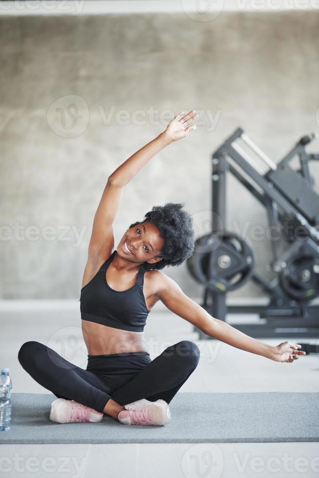 preparándose para el duro entrenamiento. mujer afroamericana con cabello  rizado y ropa deportiva tiene un día de fitness en el gimnasio 8457754 Foto  de stock en Vecteezy