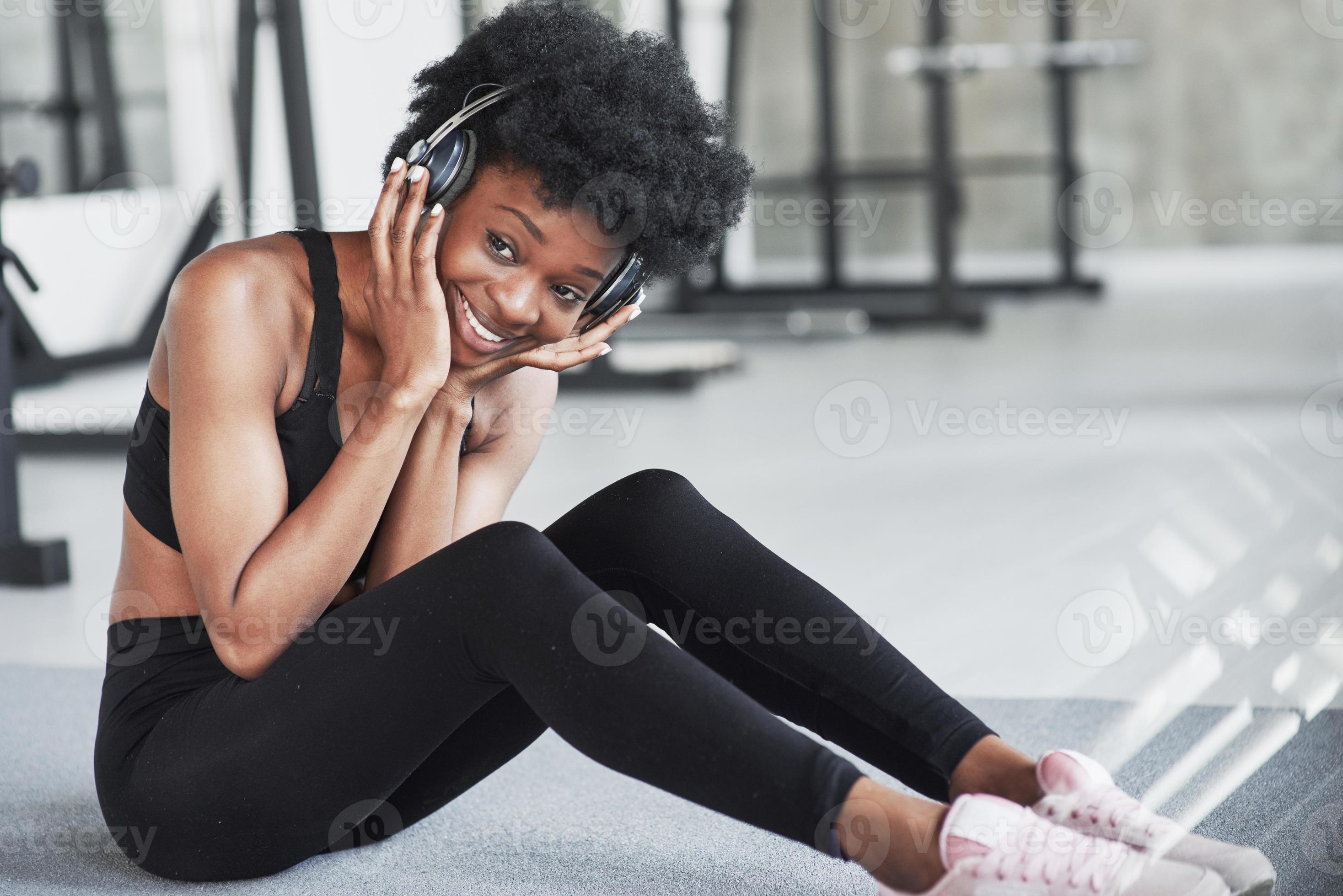 Funny and happy girl. African american woman with curly hair and in  sportive clothes have fitness day in the gym 8457777 Stock Photo at Vecteezy