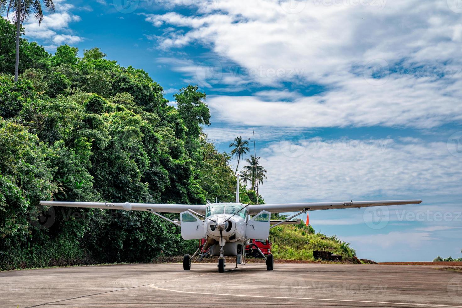 small jet plane parking in the little island of thailand with mountain behind. photo