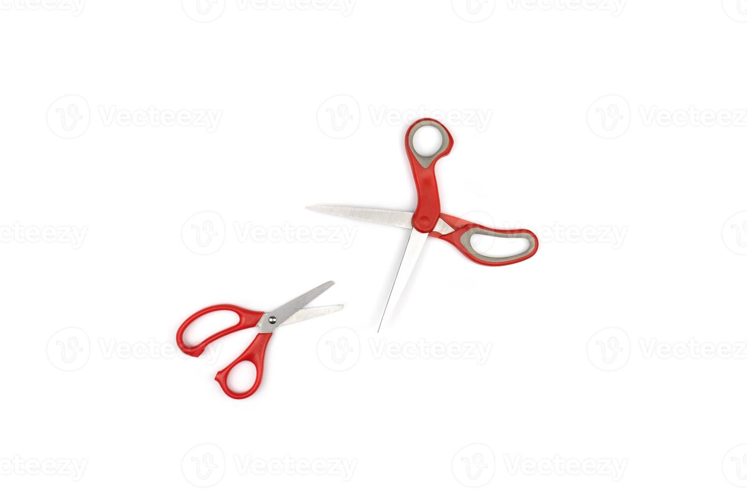 two red scissors, one big, one small are isolated on white background. Clipping paths photo