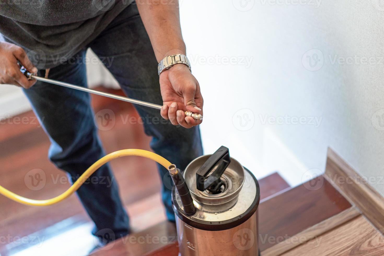 Asian Thailand termite staff company is spraying the destroy chemical liquid in to white ant nest in the wood around human house. photo