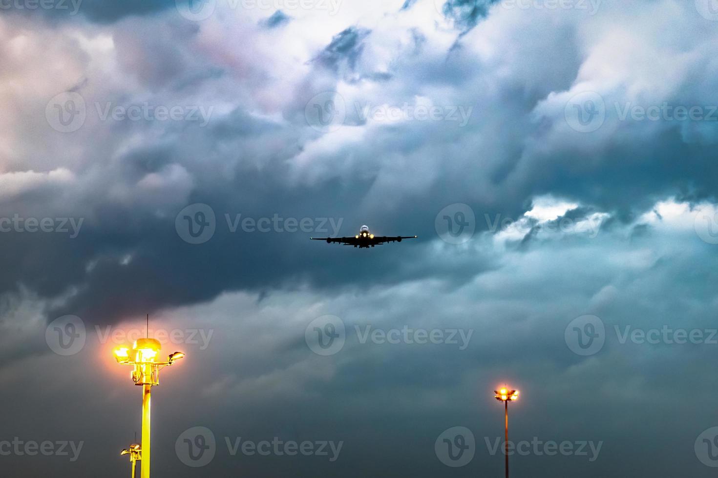 plane takes off from the airport in the night with dark cloudy sky. photo