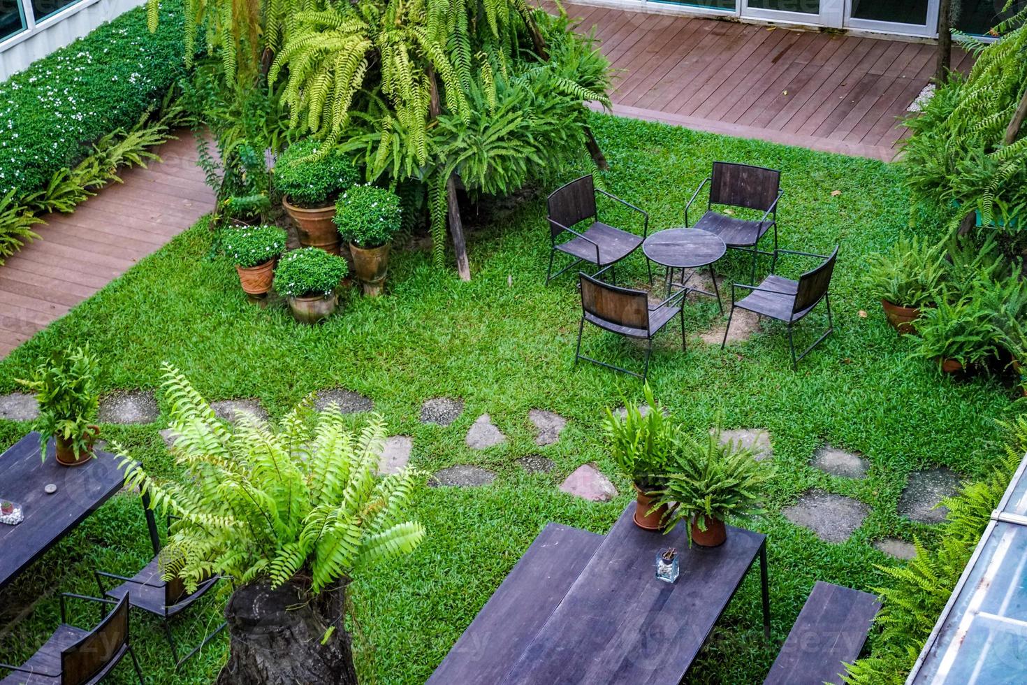 Public garden with wood chair and table on it decorate with little tree around. photo