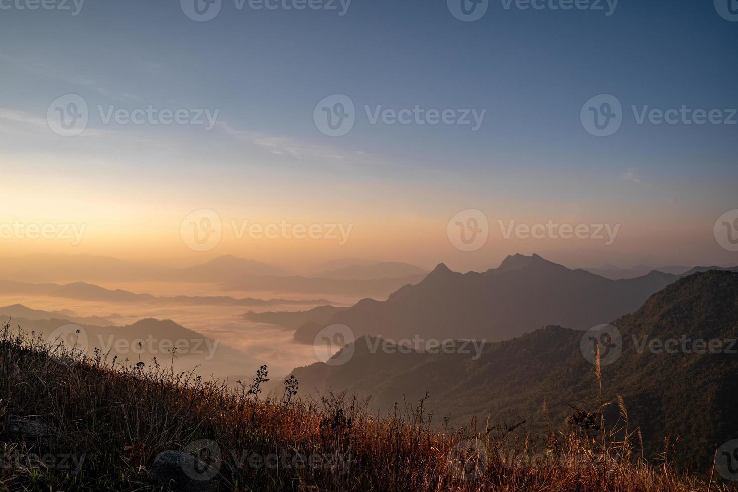 The sunrise at the mountain with the fog and cloud cover it. photo