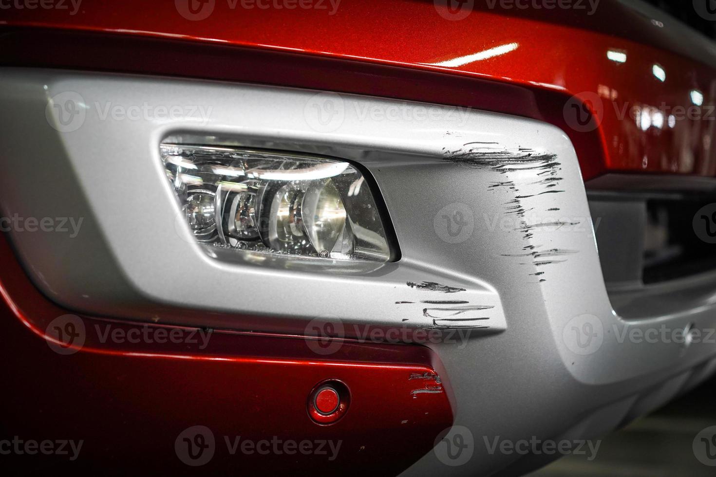 Close up New Scratch damage on the front of New red car. photo