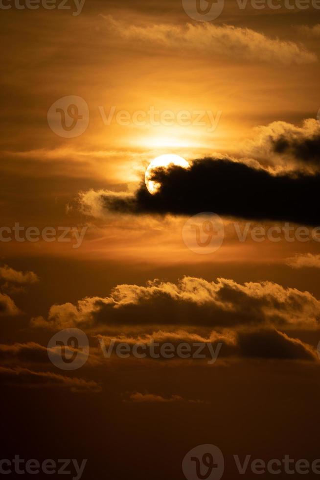 cierra el sol con una nube frente a él en el crepúsculo del atardecer. foto