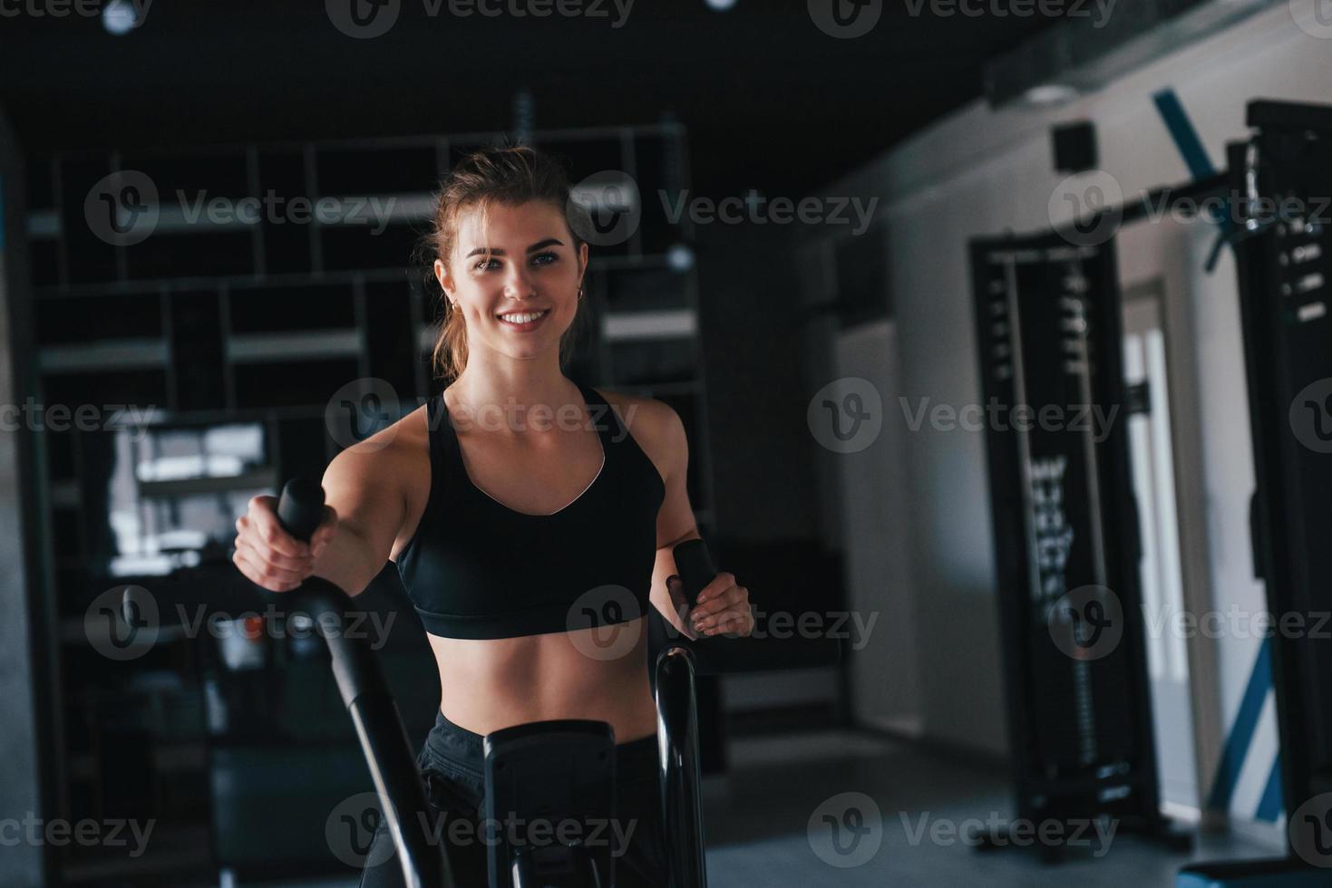 Black colored equipment. Photo of gorgeous blonde woman in the gym at her weekend time