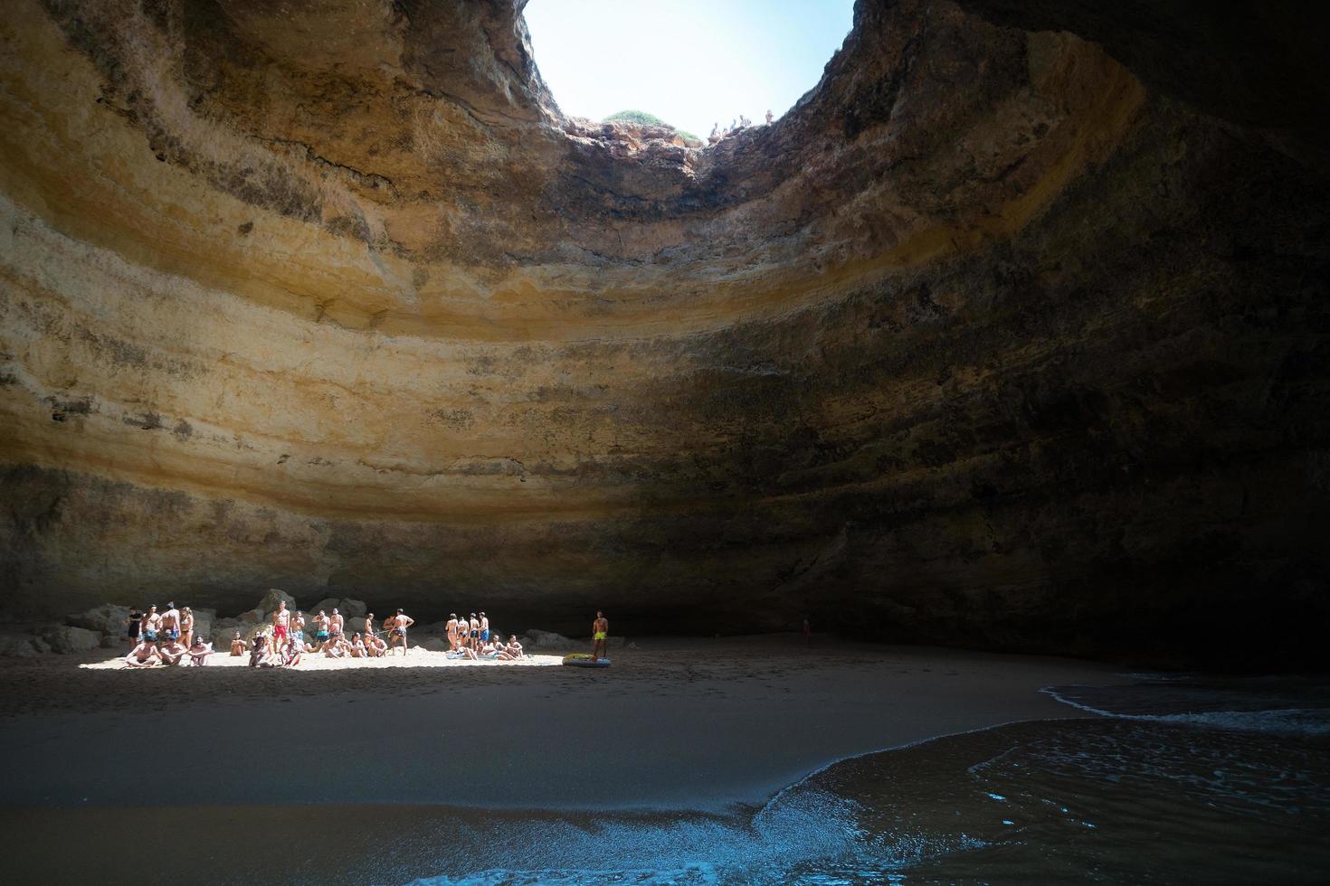 Faro,Portugal-august 14, 2017 people on the beach inside a cave in the beautiful Algarve coast of Portugal during a sunny day photo