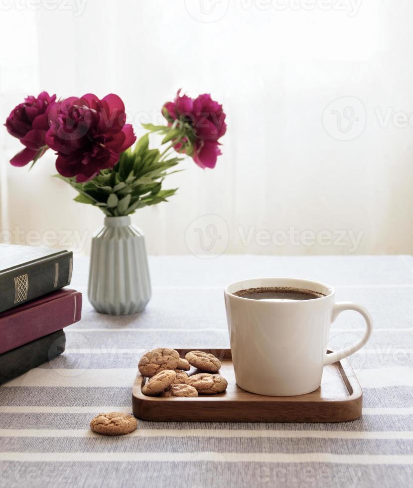Still life with a cup of coffee and a book. The atmosphere of a cozy morning. Breakfast at home or in a cafe near the window. photo