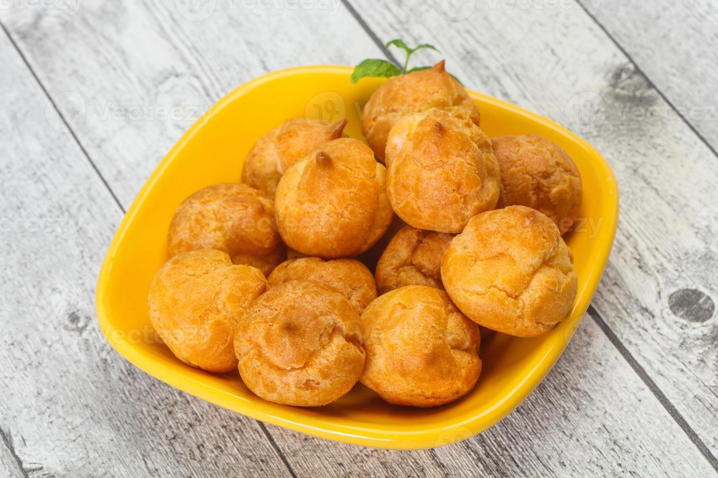 Sweet tasty profiteroles heap in the bowl photo
