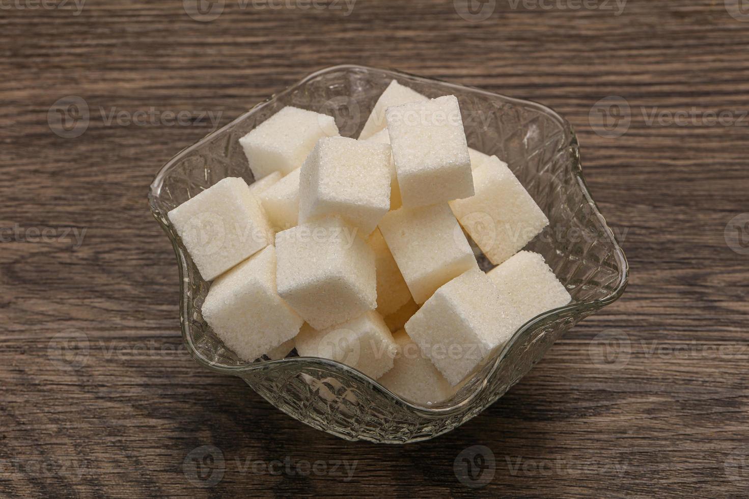 Cubos de azúcar blanco refinado en el bol foto