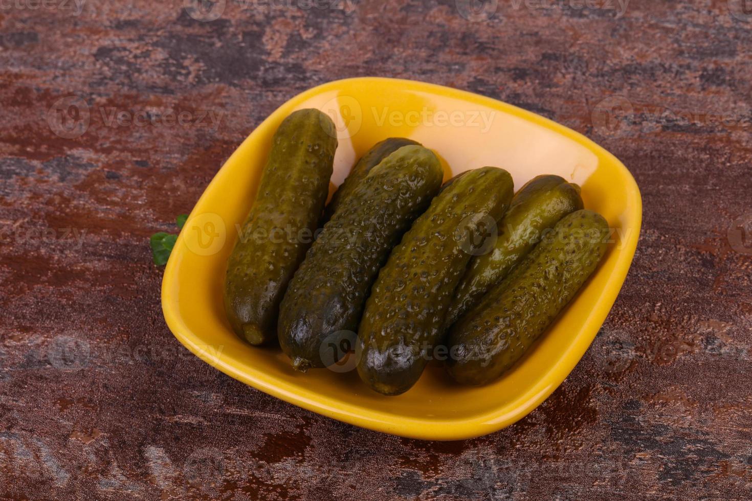 Pickled cucumbers heap in the bowl photo