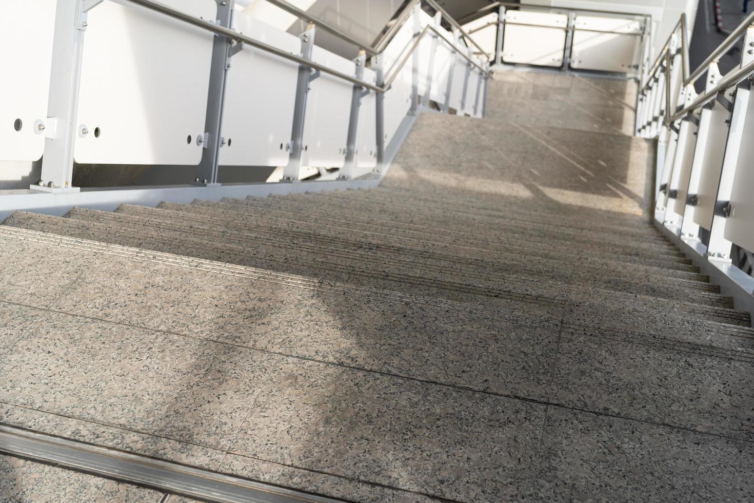 escalera pública en la estación o centro comercial para salida, entrada. escalera dentro del metro subterráneo con pasamanos de acero limpio. una escalera vacía en una estación de metro foto