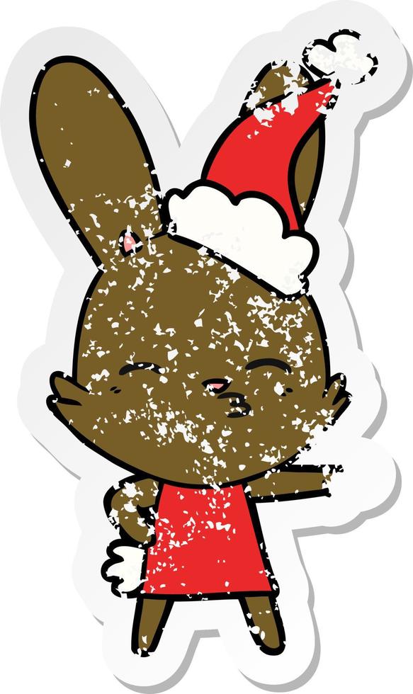 curious bunny distressed sticker cartoon of a wearing santa hat vector