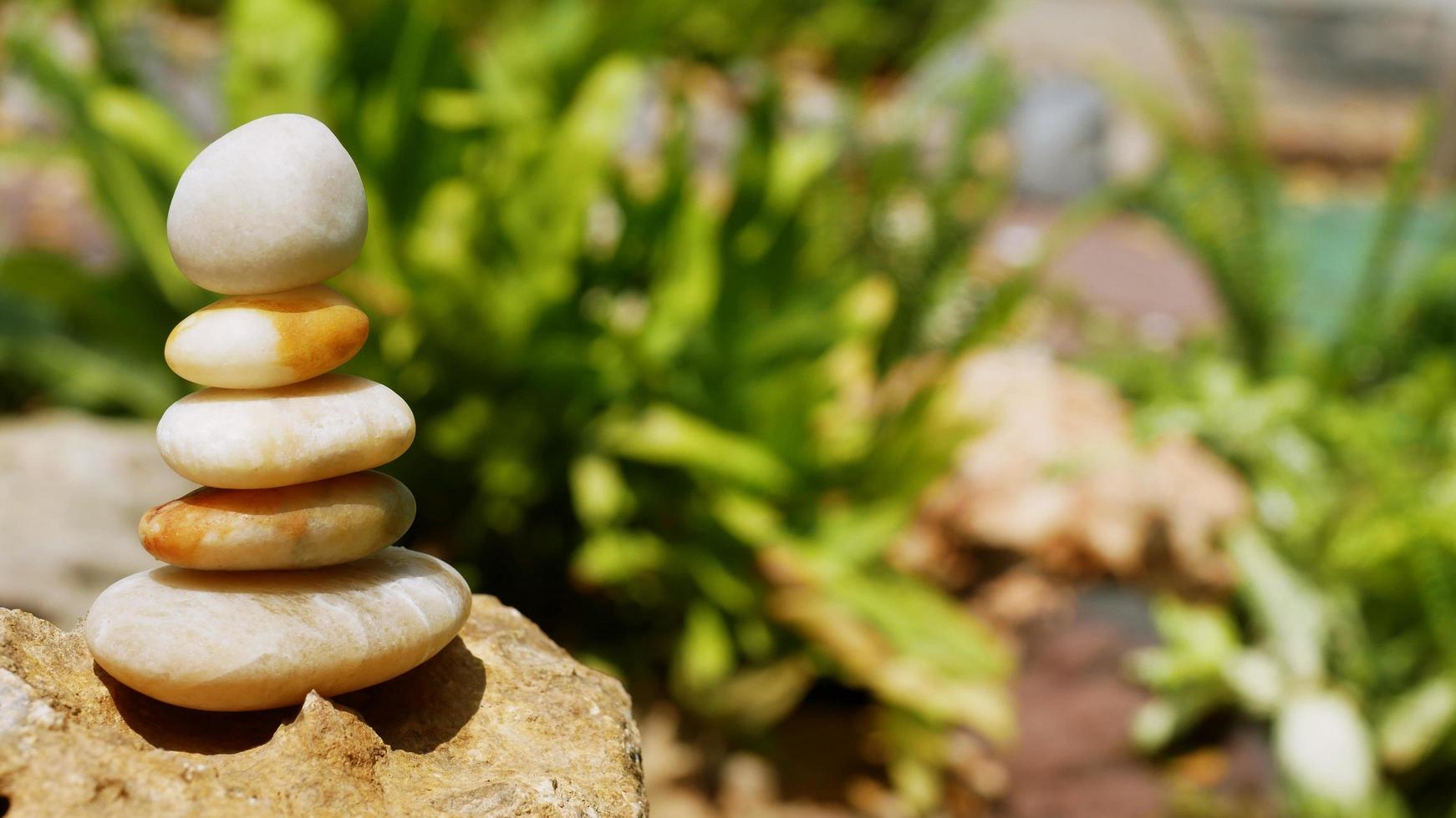 The Balance Stones are stacked as pyramids in a soft natural bokeh background, representing the calm philosophical concept of Jainism's wellness. photo